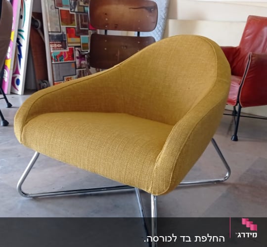 כורסה מרופדת בצבע צהוב עם רגלי מתכת